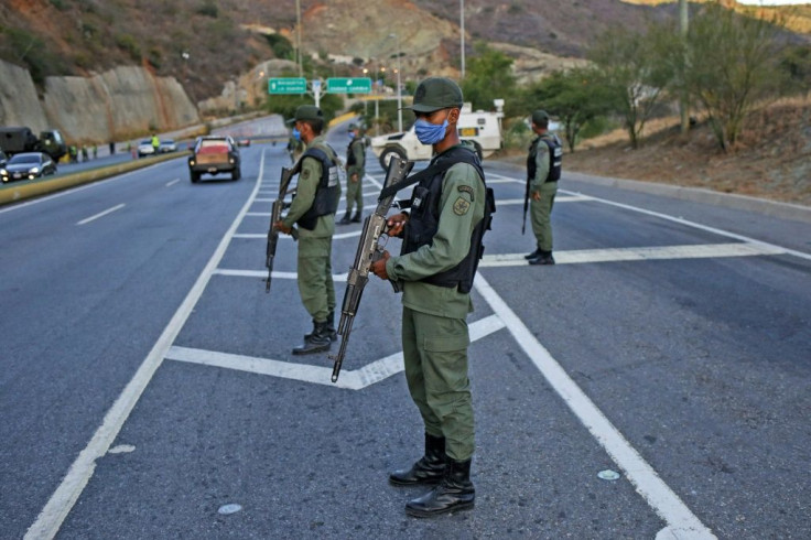 Members of the Bolivarian National Guard partially block road access to the Venezuelan capital, in Caracas -- President Nicolas Maduro retains support of the powerful military