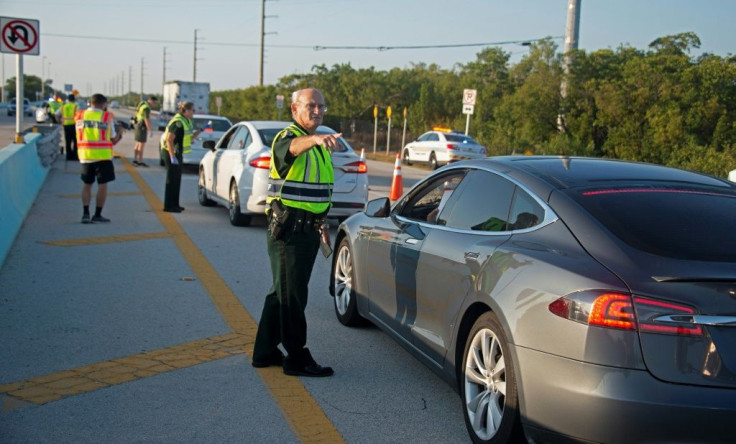 Police man a traffic stop on the route to the Florida Keys, which have been temporarily closed to visitors since March 22 because of the coronavirus crisis
