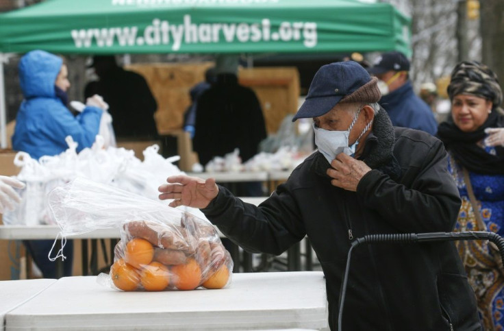 A man receives bags with food from City Harvest food bank