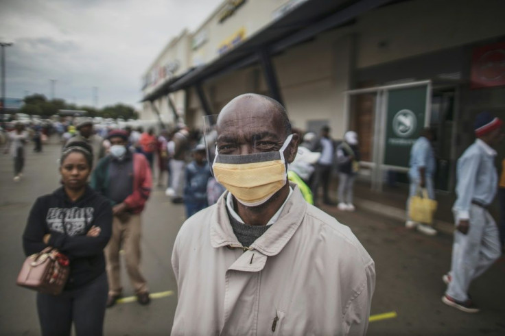 Masked: An elderly man in the Johannesburg suburb of Soweto waits in line at a pay point operated by South Africa's Social Security Agency