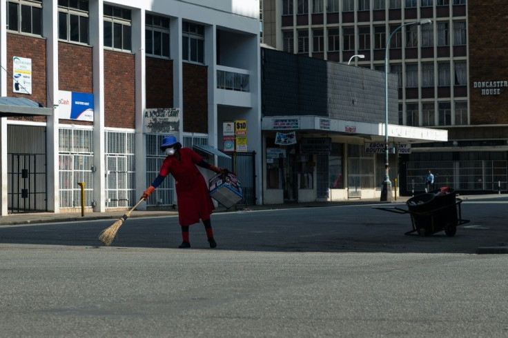 Deserted: A street cleaner in Harare on day one of Zimbabwe's three-week lockdown