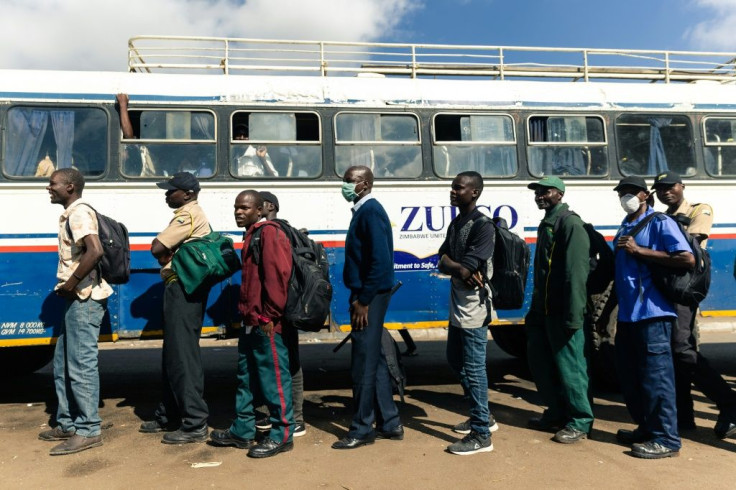 Key workers exempted from the lockdown prepare to board a government-subsidised bus in Harare