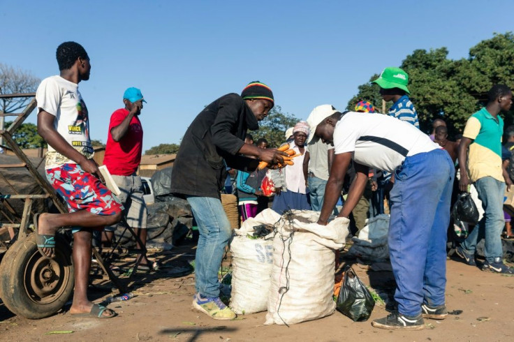 A man hawks carrots to passers-by in the Harare suburb of Mbare. All formal food markets have been closed for three weeks