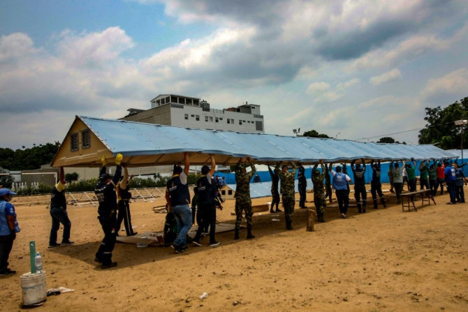 Firefighters, soldiers and workers from the office of the United Nations High Commissioner for Refugees (UNHCR)setting up a field hospital for coronavirus cases on the border with Venezuela, on March 28, 2020