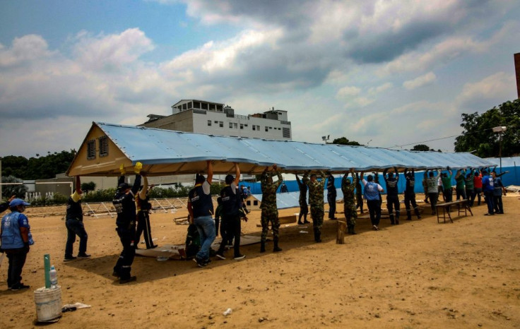 Firefighters, soldiers and workers from the office of the United Nations High Commissioner for Refugees (UNHCR)setting up a field hospital for coronavirus cases on the border with Venezuela, on March 28, 2020