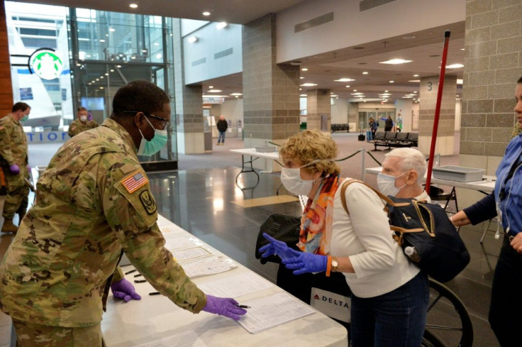 A US Army National Guard soldier helps travelers register their arrival at TF Green International Airport in Warwick, Rhode Island