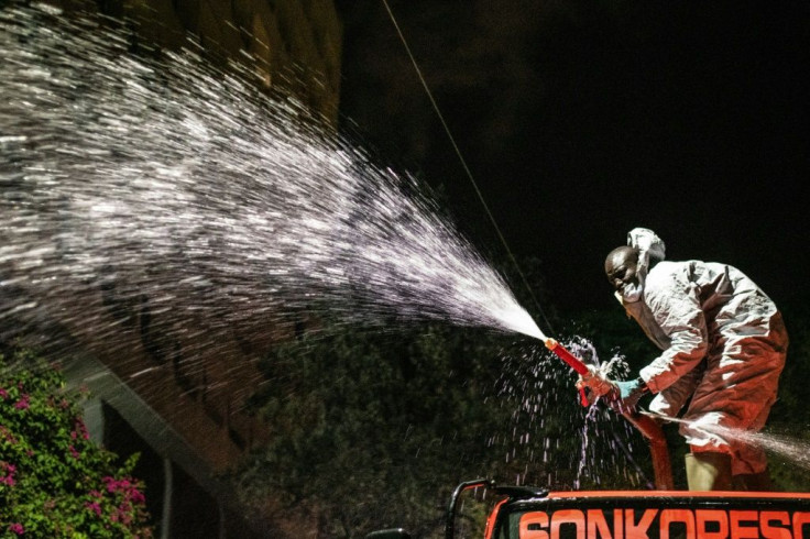 A firefighter in the Kenyan capital Nairobi sprays disinfectant onto the street during the nightly curfew