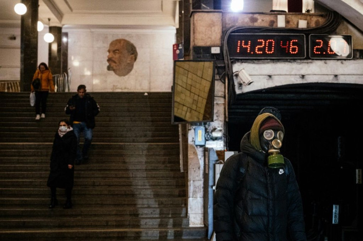 A man wearing a gas mask waits on the platform at the Biblioteka Imeni Lenina metro station in Moscow