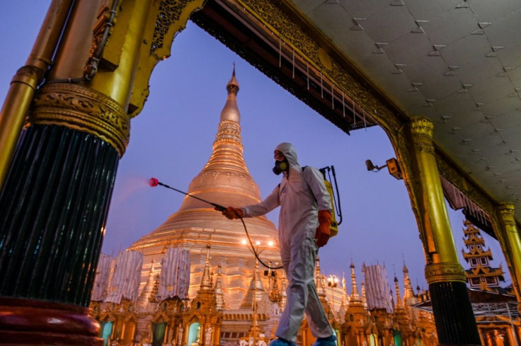 A volunteer sprays disinfectant in Shwedagon Pagoda compound as a preventive measure against the COVID-19 coronavirus in Yangon, Myanmar