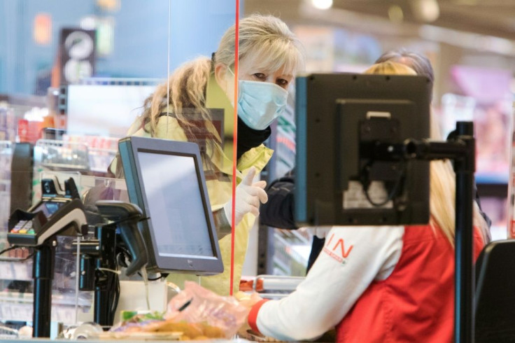 A woman wears a face protection mask at the checkout of a supermarket in Voesendorf near Vienna