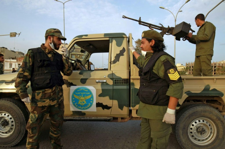 Fighters of a military battalion loyal to Libya's Khalifa Haftar patrol in the eastern city of Benghazi during a state of emergency to combat the coronavirus disease