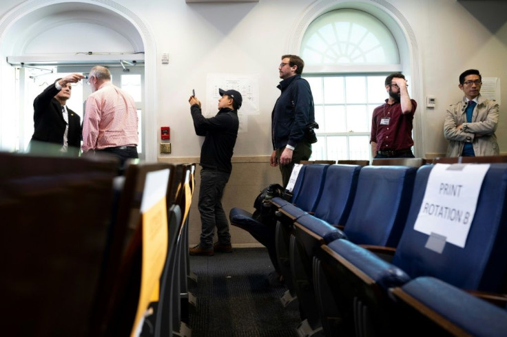 Journalists line up to have their temperatures taken ahead of a COVID-19 Task Force press briefing at the White House