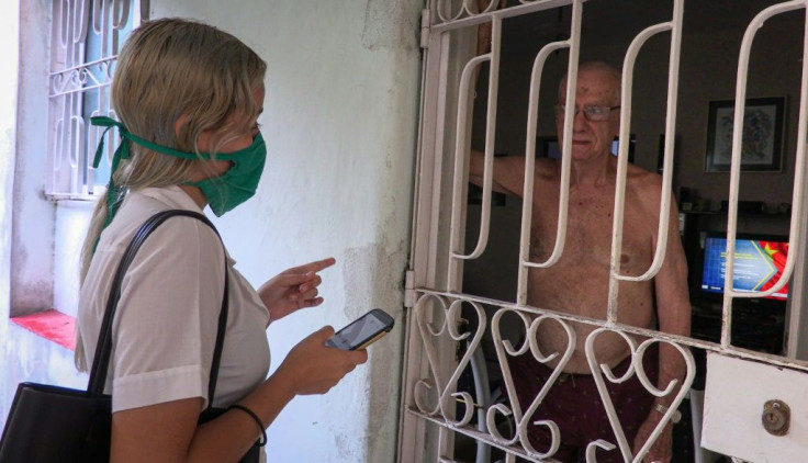 Cuban medical student Susana Diaz interviews a man as she searches for possible coronavirus cases