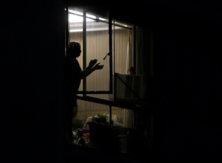 A woman in Buenos Aires, Argentina claps her hands to express gratitude to health workers, a nightly tradition during the "preventative and compulsory" lockdown