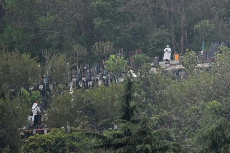 People wearing protective suits are seen in the  Biandanshan cemetery in Wuhan. For many their first outdoor act in more than two months is grim: burying loved ones