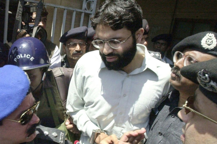 Pakistani police surround handcuffed Omar Sheikh in 2002 as he comes out of a court in Karachi
