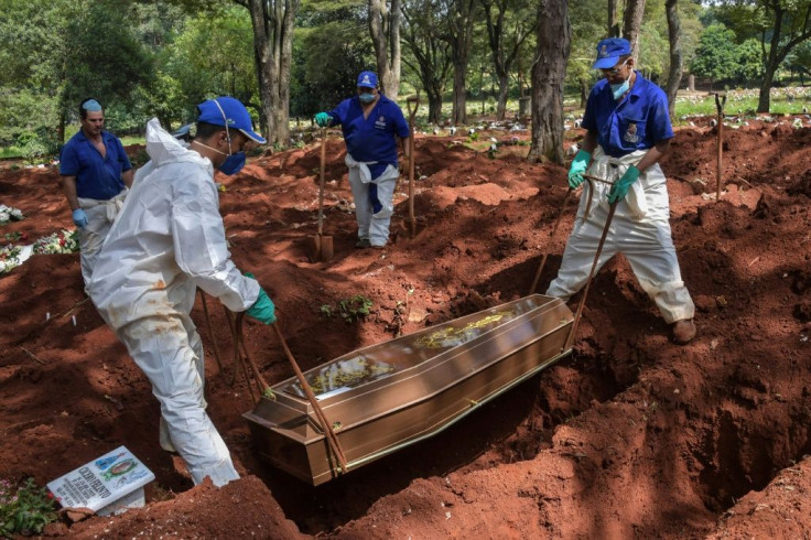 Four coffins are lowered into a single grave: one confirmed coronavirus death, and three suspected