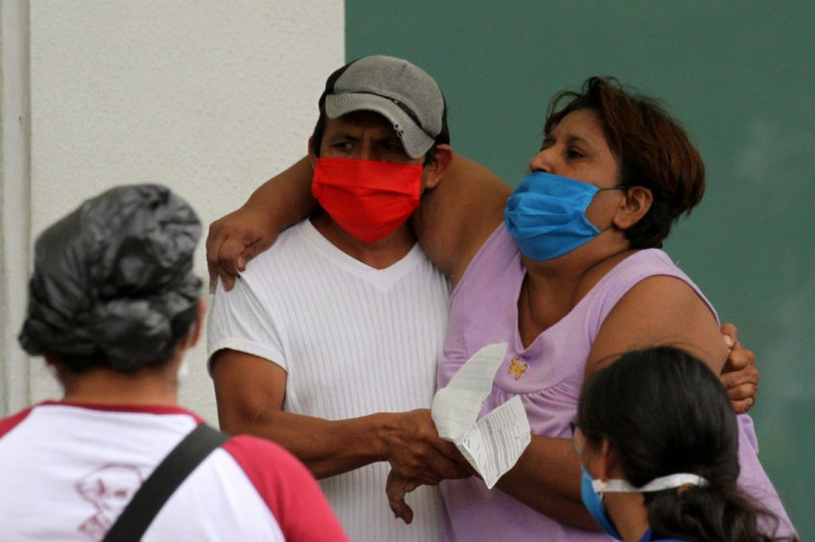 A man helps a sick woman enter a hospital in Guayaquil, Ecuador on April 1, 2020