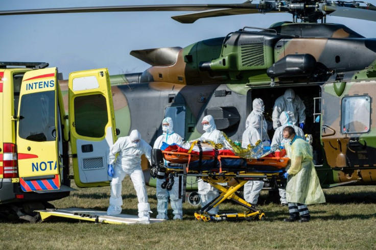 German medics take care of one of two French patients infected with the novel Covid-19 upon arrival at a little airport near Nordhausen/Harz