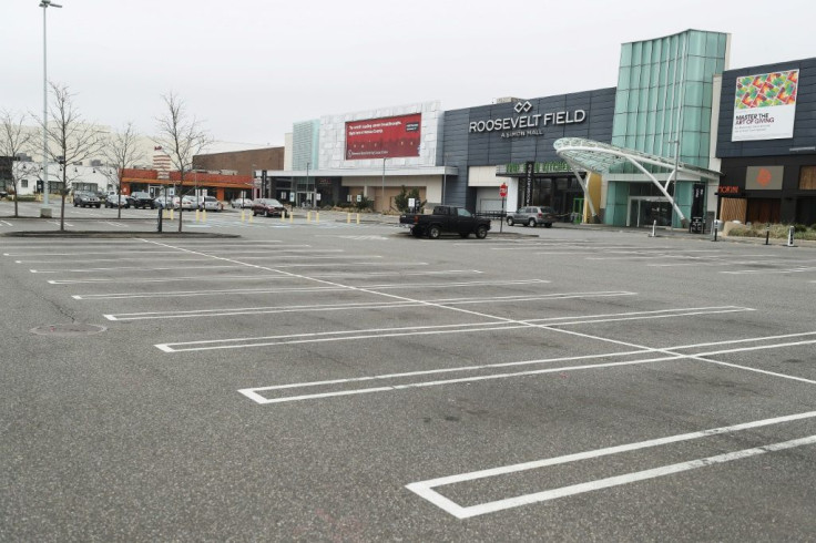 A shopping mall parking lot sits empty in East Garden City, New York in March 2020