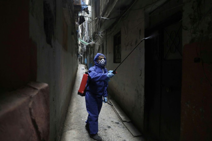 A volunteer sprays disinfectant in the narrow alleyways of the Shatila Palestinian refugee camp in the Lebanese capital Beirut