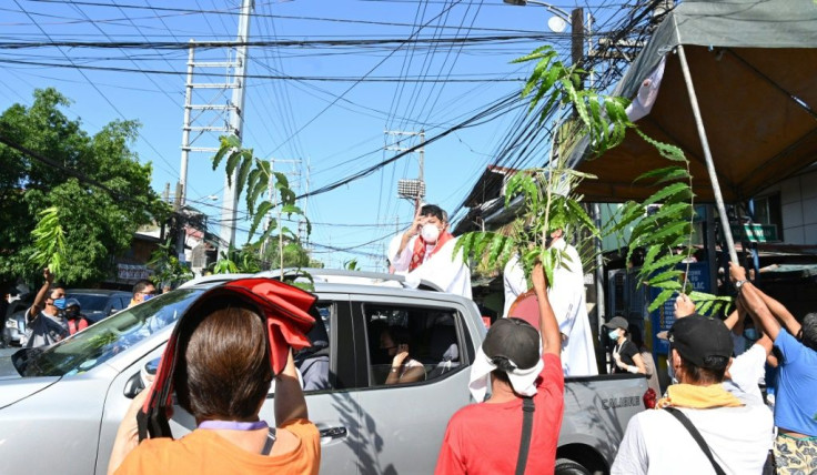 A Roman Catholic priest blesses the faithful from the back of a pick-up truck in Manila