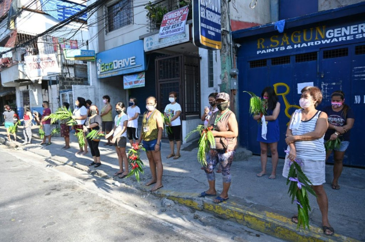 People lined up with palm fronds as the priests drive by