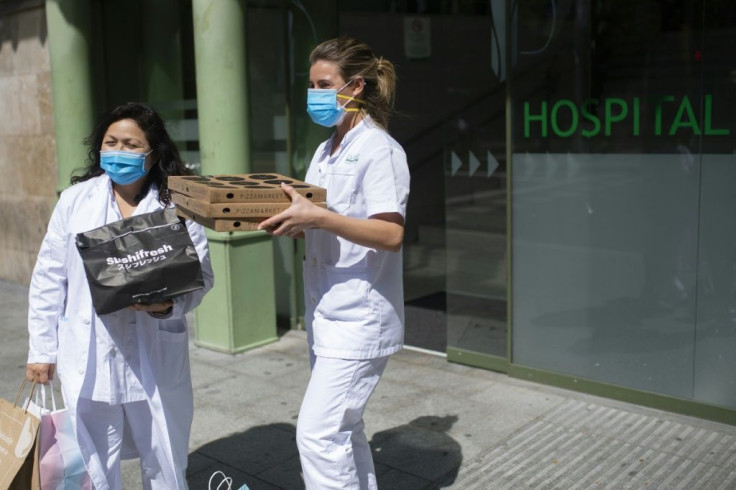 Two healthcare workers receive sushi and pizzas delivered by Delivery4Heroes to Barcelona's Hospital Clinic