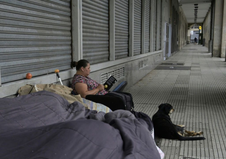 Homeless woman Maria reads a book on the sidewalk where she lives in Buenos Aires