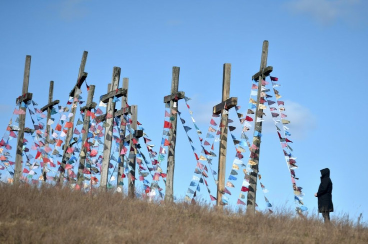 A man stands in front of giant crosses  in the town of Achmiany, some 130 km northwest of Minsk, during Palm Sunday celebrations