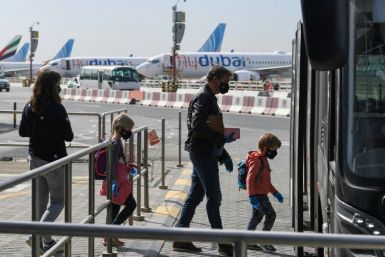 Passengers bound for Frankfurt board a shuttle bus at Dubai airport as UAE carriers Emirates Airlines and Etihad Airways resume a limited number of flights after being grounded amid the coronavirus pandemic