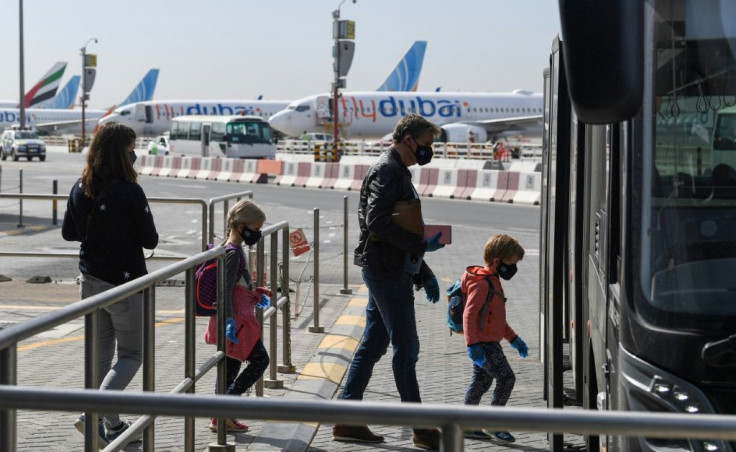 Passengers bound for Frankfurt board a shuttle bus at Dubai airport as UAE carriers Emirates Airlines and Etihad Airways resume a limited number of flights after being grounded amid the coronavirus pandemic