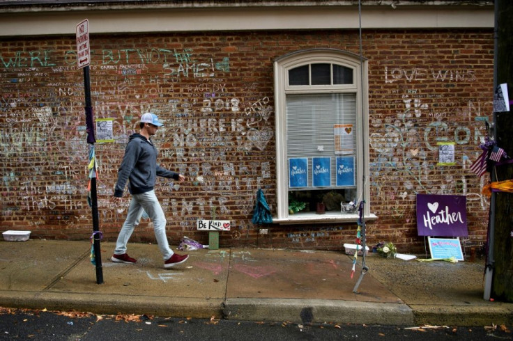 A man walks past a memorial to Heather Heyer and the other victims of a hit-and-run during a neo-Nazi rally in Charlottesville, Virginia