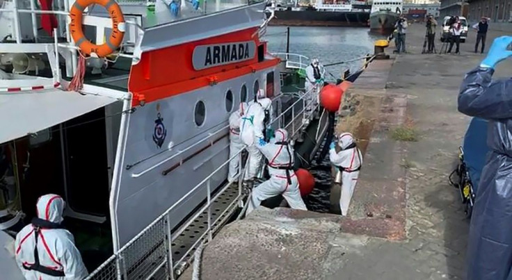 Medics help a sick passenger from an Australian liner off a Uruguay navy launch in Montevideo, on April 3, 2020