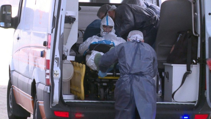 A 75-year-old Australian is helped aboard an ambulance in Montevideo after being taken off the virus-stricken Greg Mortimer cruise ship on April 3, 2020