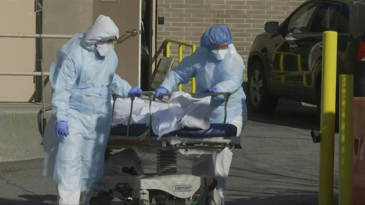 IMAGESMedical personnel wearing full protective gear transport two bodies on stretchers from New York's Wyckoff Heights Medical Center to a refrigerated trailer repurposed as a makeshift  morgue. As the United States' death toll races towards 10,000, incl