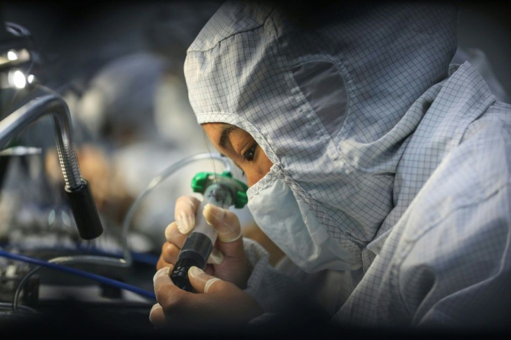 A factory worker on the production line of a photoelectric facility in Wuhan, which is slowly c oming back to life