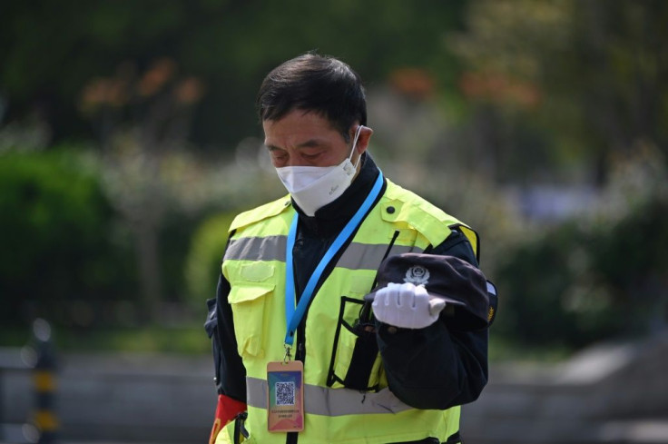A policeman bows his head in Wuhan as China observed three minutes of silence to mourn those who died in the coronavirus pandemic