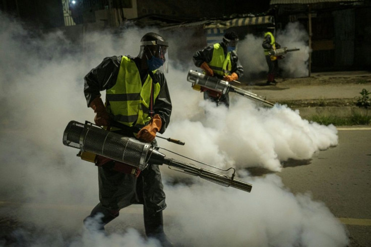 Volunteers fumigate a street in Nairobi to curb the spread of COVID-19