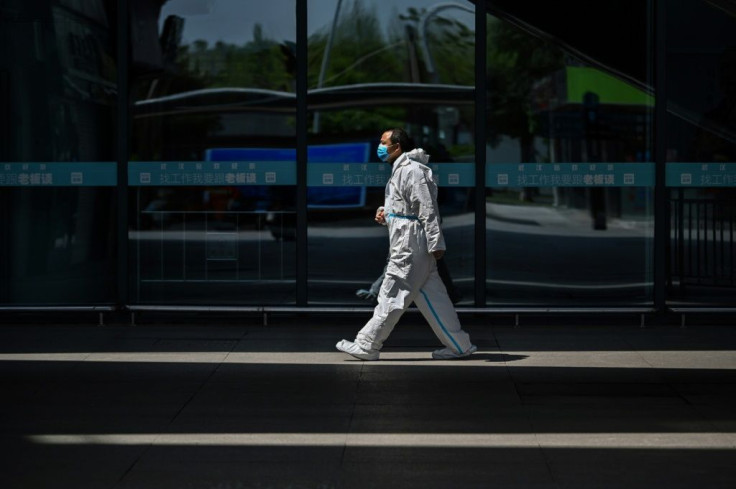 A railway worker wearing a protective suit walks at the station in Wuhan -- the lockdown on outbound travel has been lifted after more than two months
