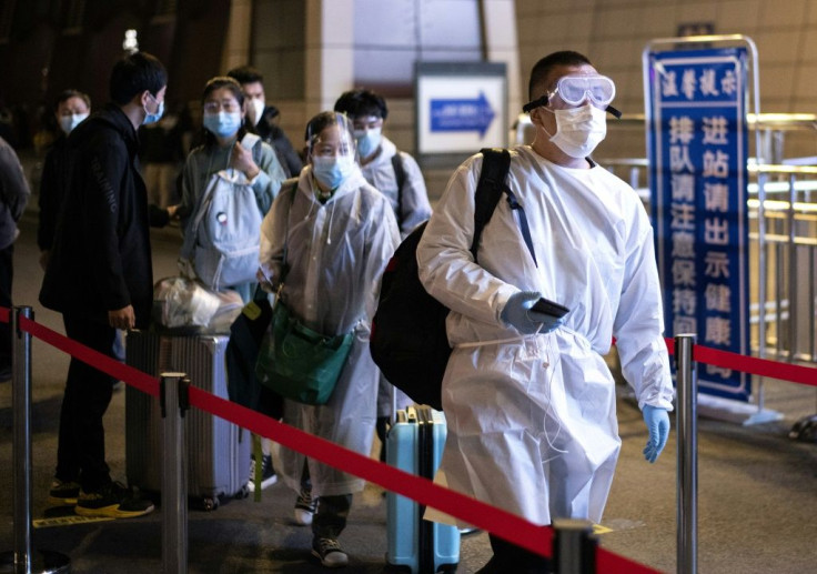 Passengers wear hazmat suit as they arrive at the Wuhan Wuchang Railway Station in leave the original epicenter of the COVID-19 coronavirus