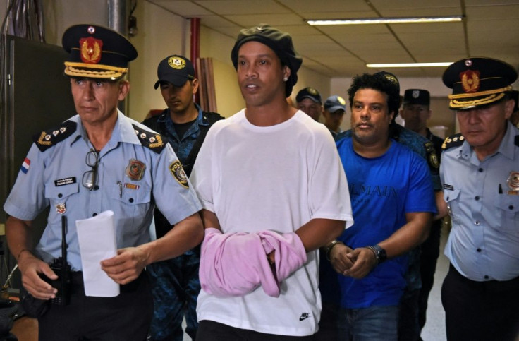 Former Brazil star Ronaldinho (C) and his brother Roberto Assis (R) arrive at Asuncion's Palace of Justice to appear before a public prosecutor on March 7, 2020