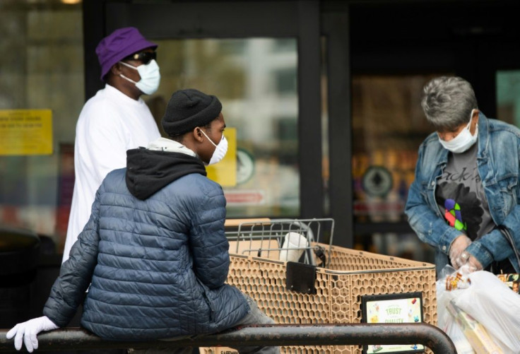 People wearing masks to try and prevent the spread of COVID-19 leave a supermarket in Washington, DC, April 7, 2020