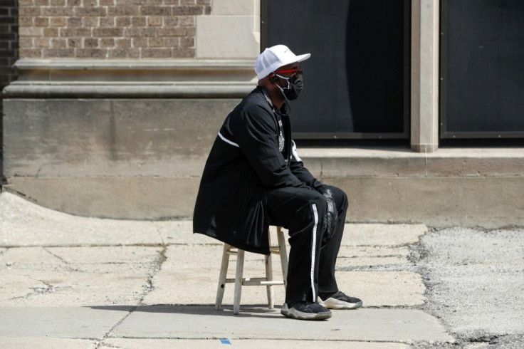 A man waits in long line to vote in a presidential primary election outside the Riverside High School in Milwaukee, Wisconsin, on April 7, 2020