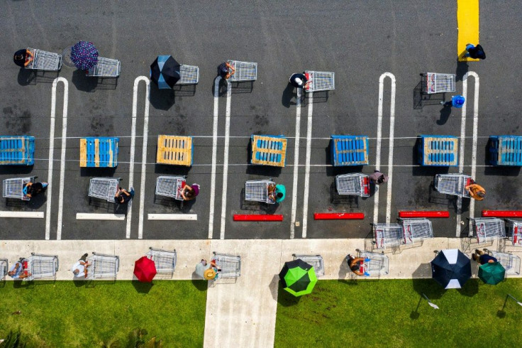 People keep their distance as they queue at a retail store in Carolina, Puerto Rico