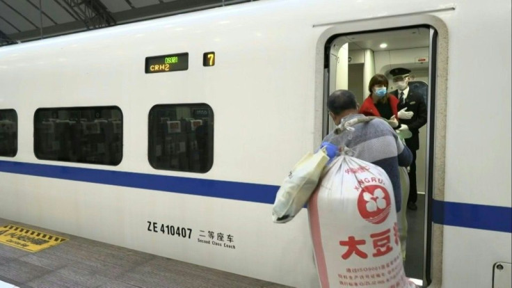 Travellers board a train departing from Wuhan Railway Station as Chinese authorities lift a more than two-month ban on travel from the city in Hubei Province