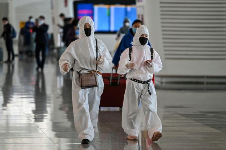 Passengers in protective gear walk through Tianhe Airport after it was reopened in Wuhan in China's central Hubei province