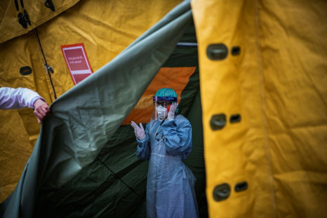 A medical staffer at Sophiahemmet hospital talks on a cell phone inside a tent for testing and receiving potential coronavirus patients in Stockholm, Sweden