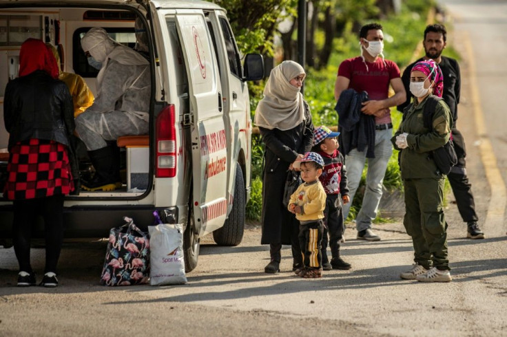 Members of Syria's Kurdish Red Crescent collect samples from passengers upon arrival at Qamishli airport