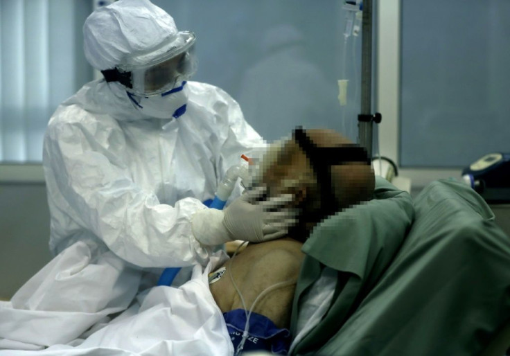 A nurse tends to a patient suffering from COVID-19 in an isolated intensive care unit at the Rafik Hariri public hospital in the Lebanese capital Beirut